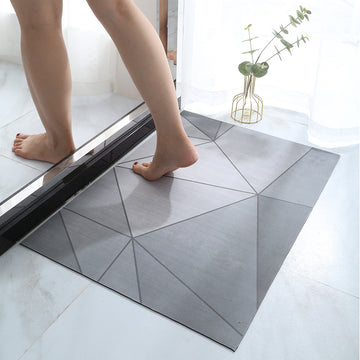 Person stepping onto a geometric-patterned bath mat in a bathroom setting.