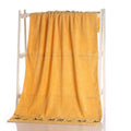 Yellow towel draped over a white rack on a white background