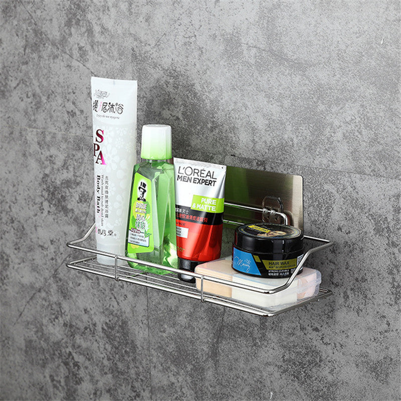 Wall-mounted shower caddy with various shampoo and bathroom bottles on a gray concrete wall