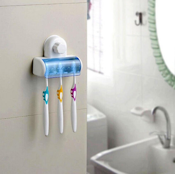 Wall-mounted toothbrush holder with three colorful toothbrushes on a light gray wall.