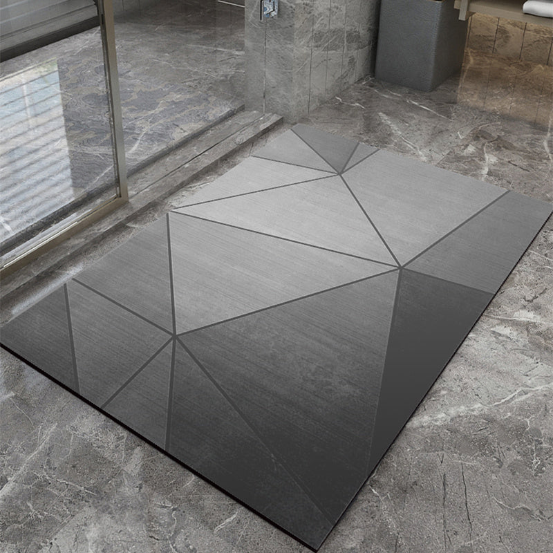 Geometric-patterned gray bathmat on a stone floor