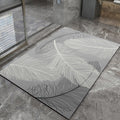 Gray bath mat with leaf pattern on a stone floor