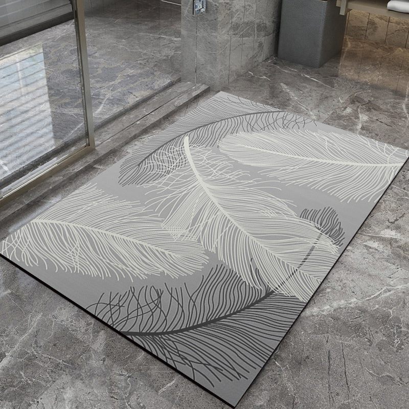 Gray bath mat with leaf pattern on a stone floor