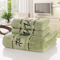 Stack of green towels with bamboo design on a white surface