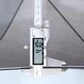 Digital vernier caliper measuring a bathmat's thickness with a clear background